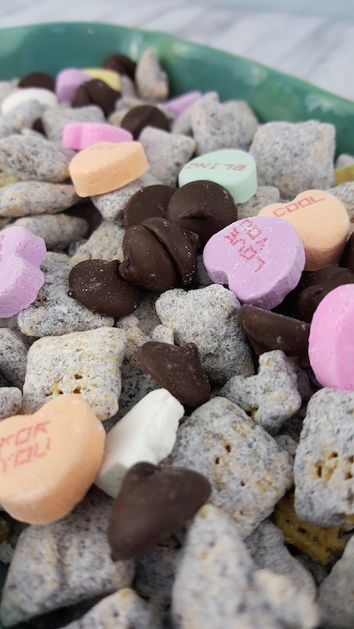 Valentine's Day Muddy Buddies: Mix a traditional Muddy Buddies Recipe together with Valentine's Hearts to create a lovely snack mix!